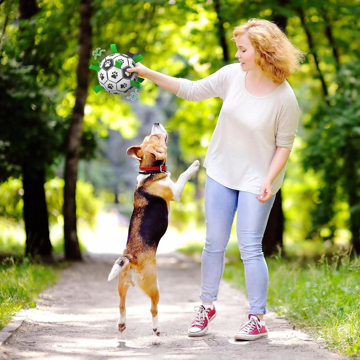 woman playing with a dog in a park.